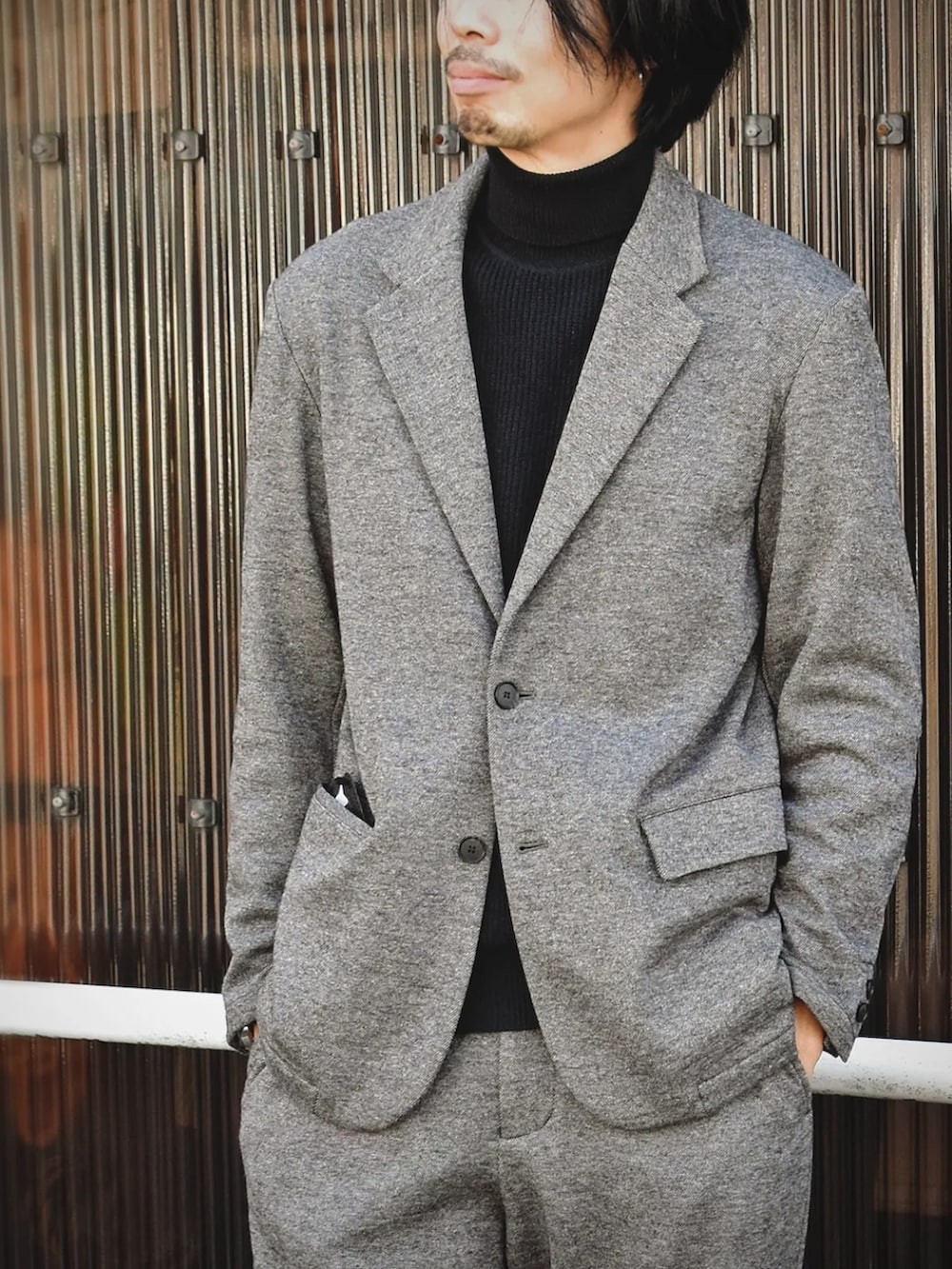 ベージュ系のその他パンツ、ベージュ系のテーラードジャケット、ブラック系のニット/セーターを着用したメンズの冬コーディネートの3枚目の写真