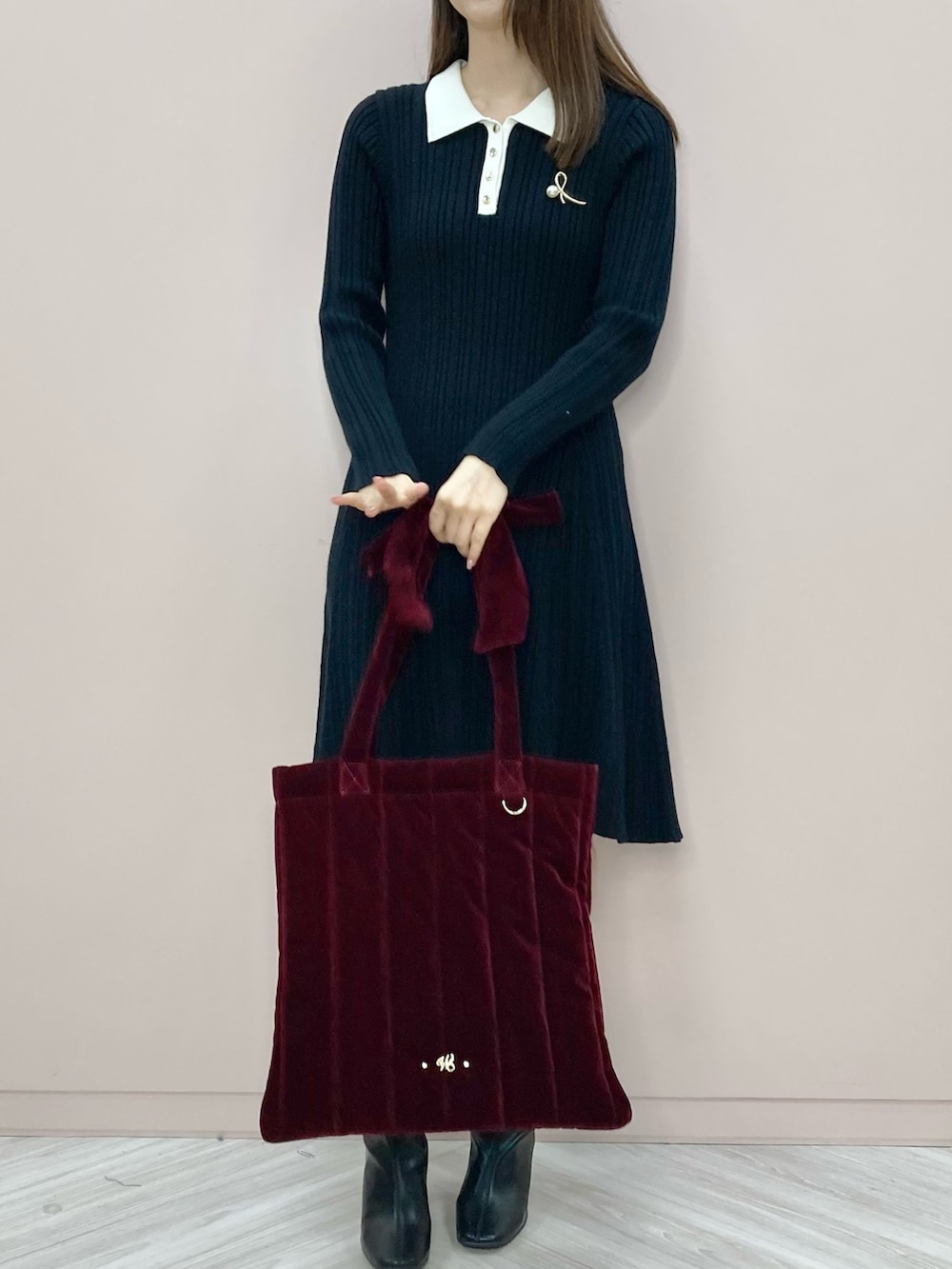 ブラック系のワンピース、レッド系のトートバッグを着用したレディースの秋コーディネートの2枚目の写真