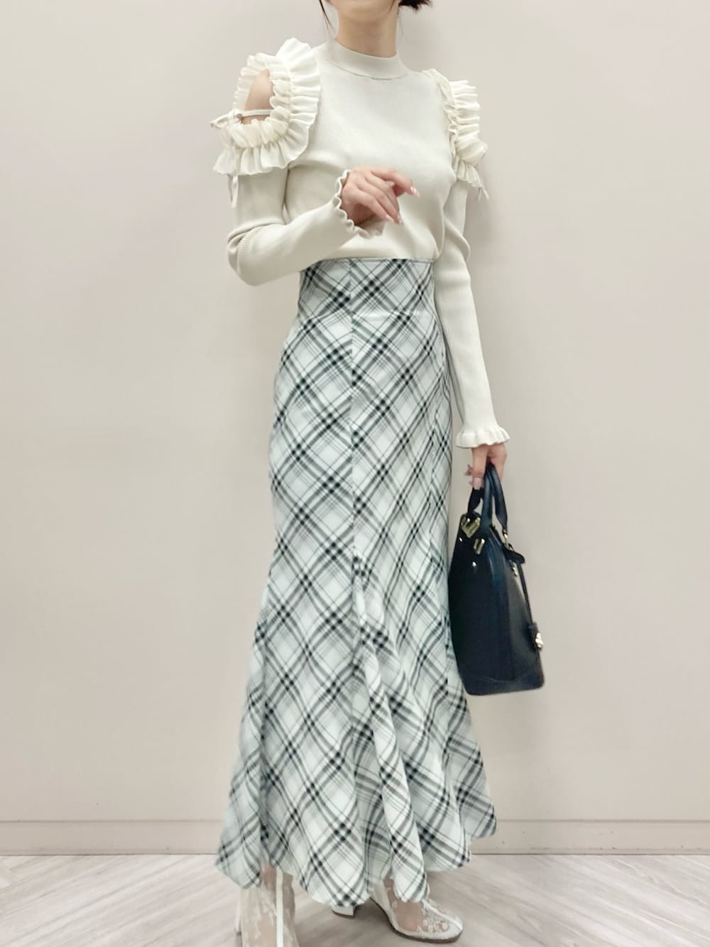 ブラック系のスカートを着用したレディースの秋コーディネートの2枚目の写真