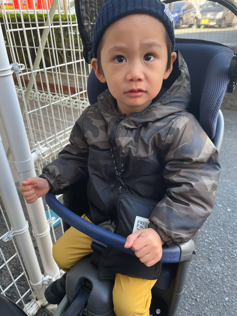 イエロー系のパンツ、ブラック系のブルゾンを着用したキッズの冬コーディネートの3枚目の写真