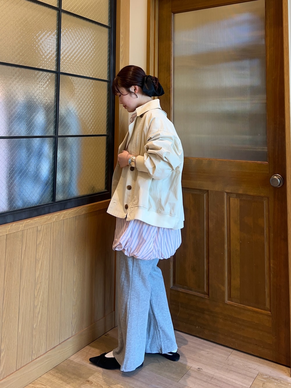 ベージュ系のトレンチコート、ホワイト系のシャツ/ブラウス、グレー系のその他パンツを着用したレディースの春コーディネートの2枚目の写真