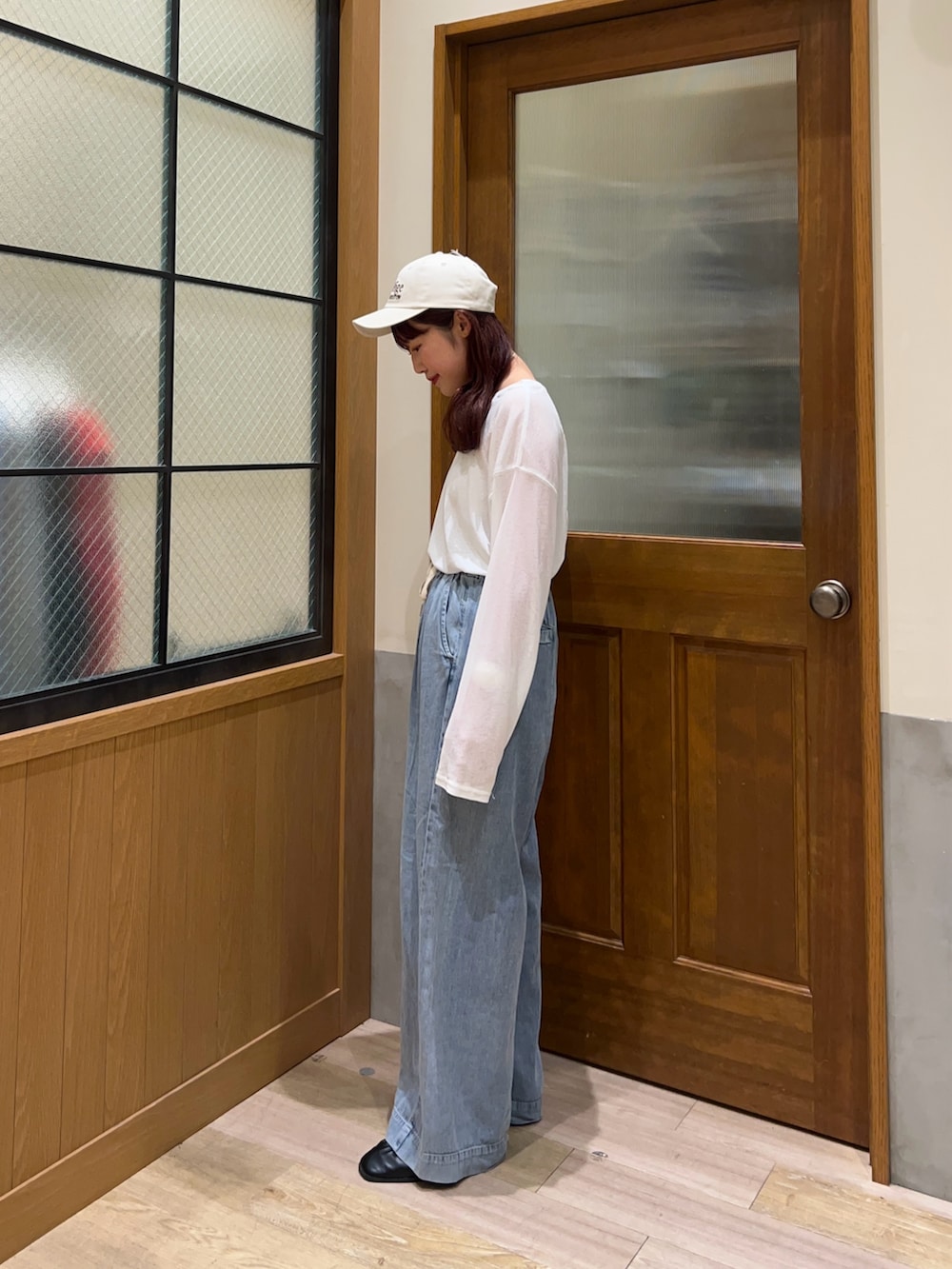 ブルー系のデニムパンツ、ホワイト系のTシャツ/カットソー、ホワイト系のキャップを着用したレディースの春コーディネートの2枚目の写真
