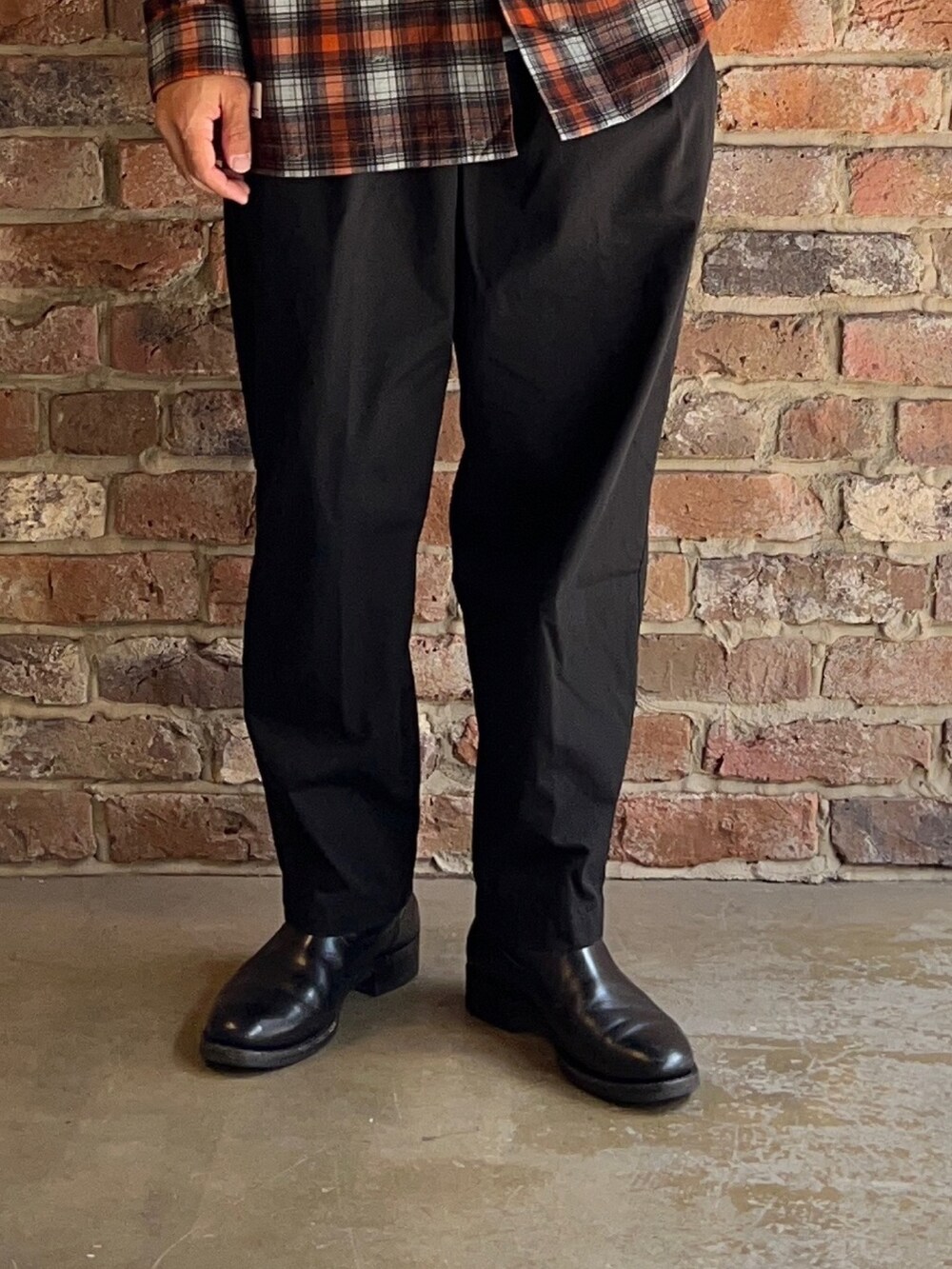 ブラック系のチノパンツ、オレンジ系のシャツ/ブラウスを着用したメンズの夏コーディネートの3枚目の写真