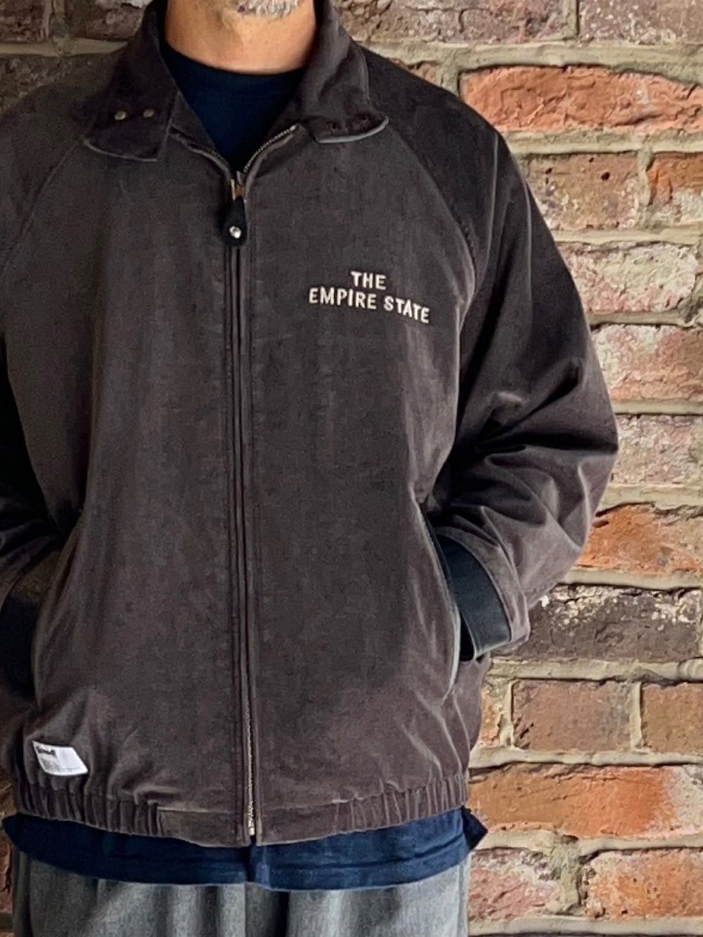 グレー系のブルゾン、グレー系のパンツを着用したメンズの秋コーディネートの2枚目の写真