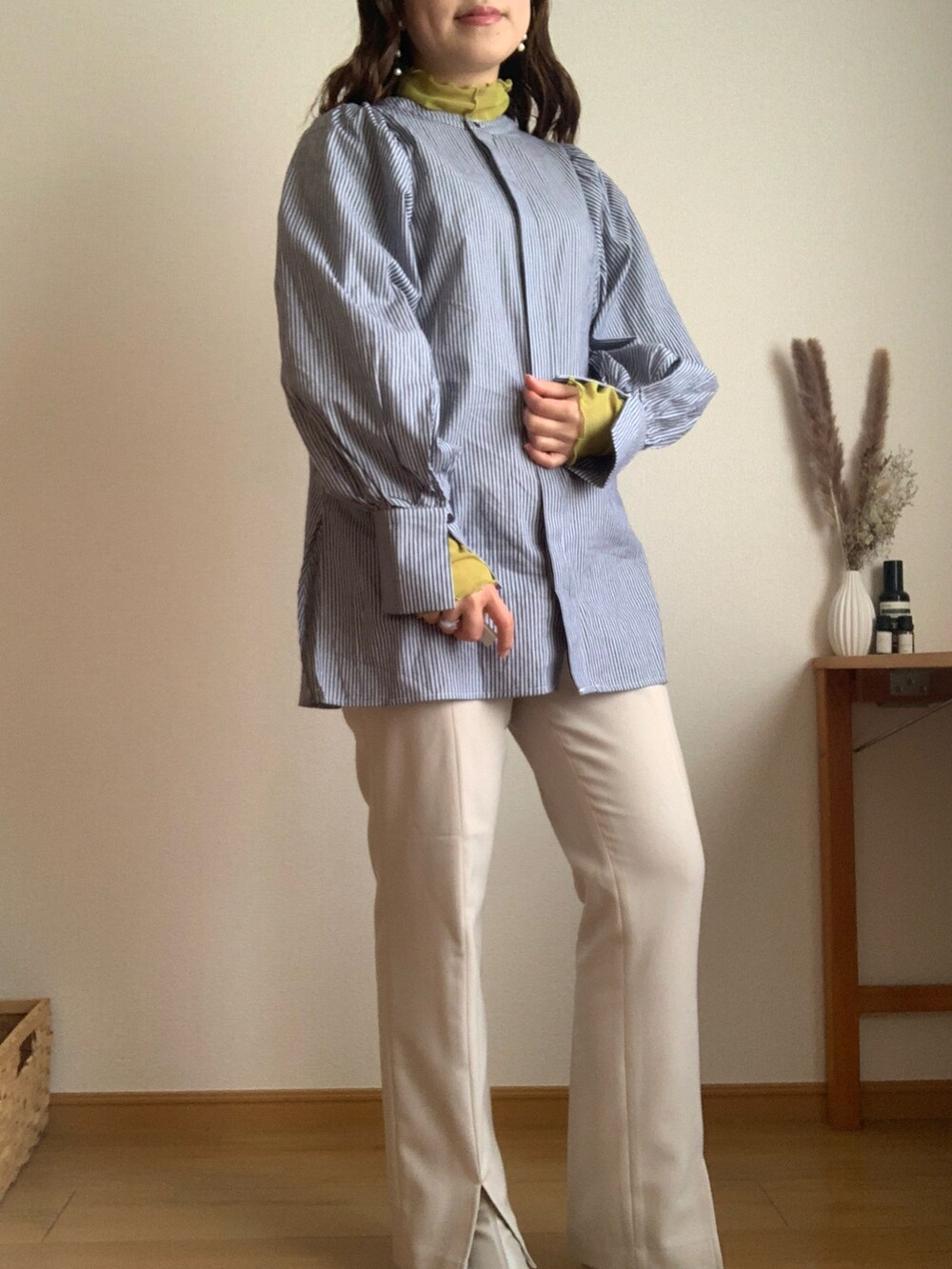 ブラウン系のショルダーバッグ、ブラウン系のパンプス、ブルー系のシャツ/ブラウスを着用したレディースの冬コーディネートの3枚目の写真