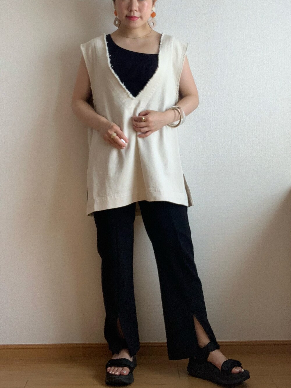 ホワイト系のベスト、ブラウン系のキャップを着用したレディースの夏コーディネートの2枚目の写真