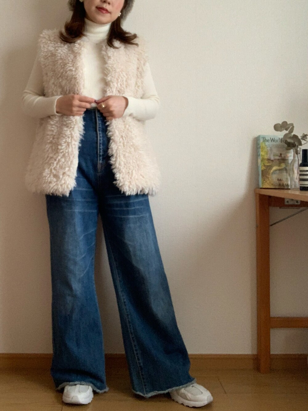 グリーン系のノーカラージャケット、ブルー系のデニムパンツ、ホワイト系のスニーカーを着用したレディースの冬コーディネートの2枚目の写真