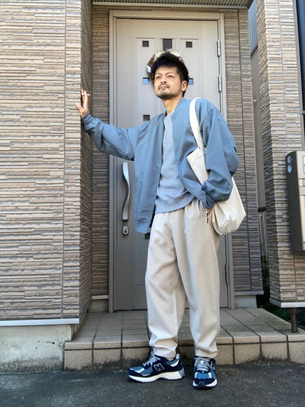 ホワイト系のパンツ、ブルー系のスニーカー、ホワイト系のトートバッグを着用したメンズの冬コーディネートの2枚目の写真