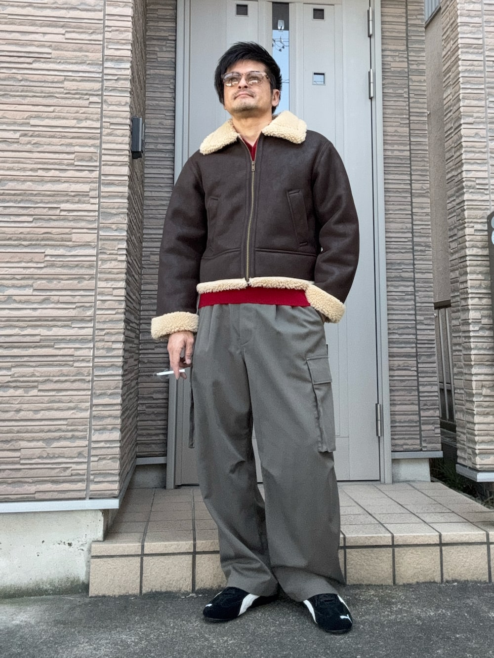 ブラック系のスニーカー、グレー系のカーゴパンツ、レッド系のニット/セーターを着用したメンズの冬コーディネートの2枚目の写真