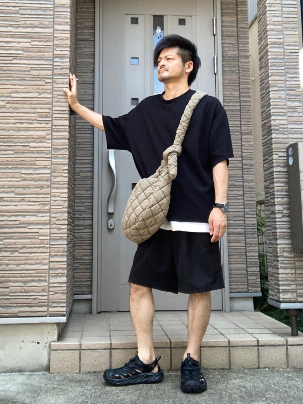 ブラック系のその他パンツ、ブラック系のサンダル、グリーン系のショルダーバッグを着用したメンズの夏コーディネートの2枚目の写真