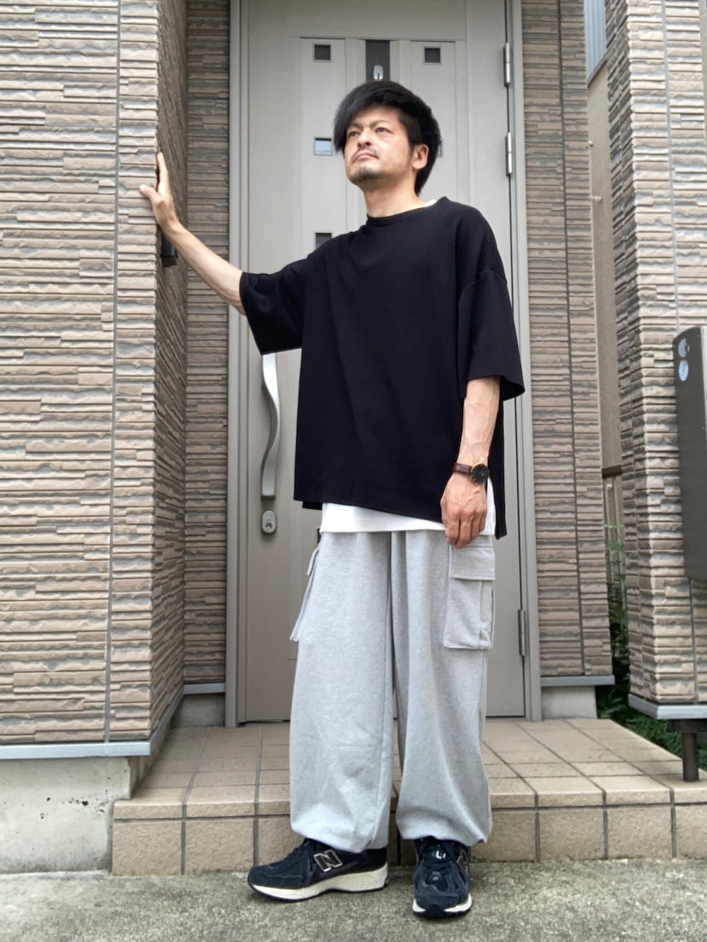 グレー系のスウェットパンツ、ブラック系のスニーカー、ブラック系のTシャツ/カットソーを着用したメンズの秋コーディネートの2枚目の写真