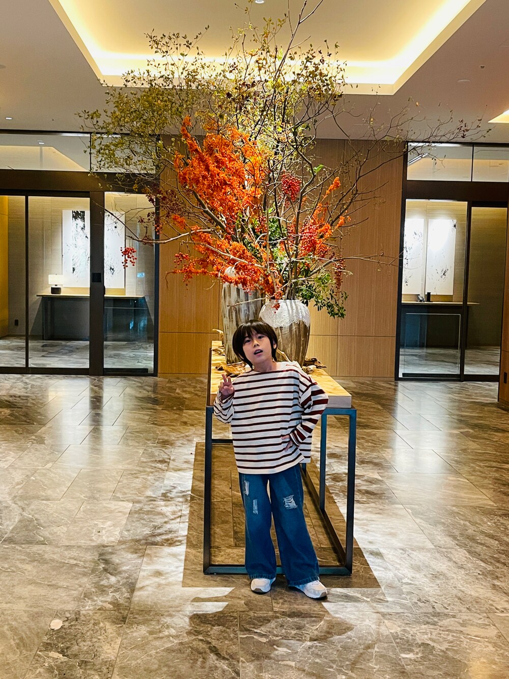 ブルー系のデニムパンツ、ブラウン系のTシャツ/カットソーを着用したキッズの春コーディネートの3枚目の写真