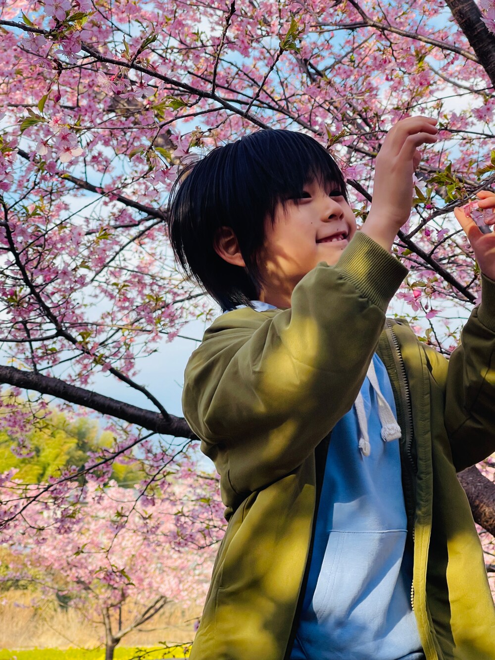 グリーン系のブルゾン、ホワイト系のその他パンツを着用したキッズの春コーディネートの2枚目の写真