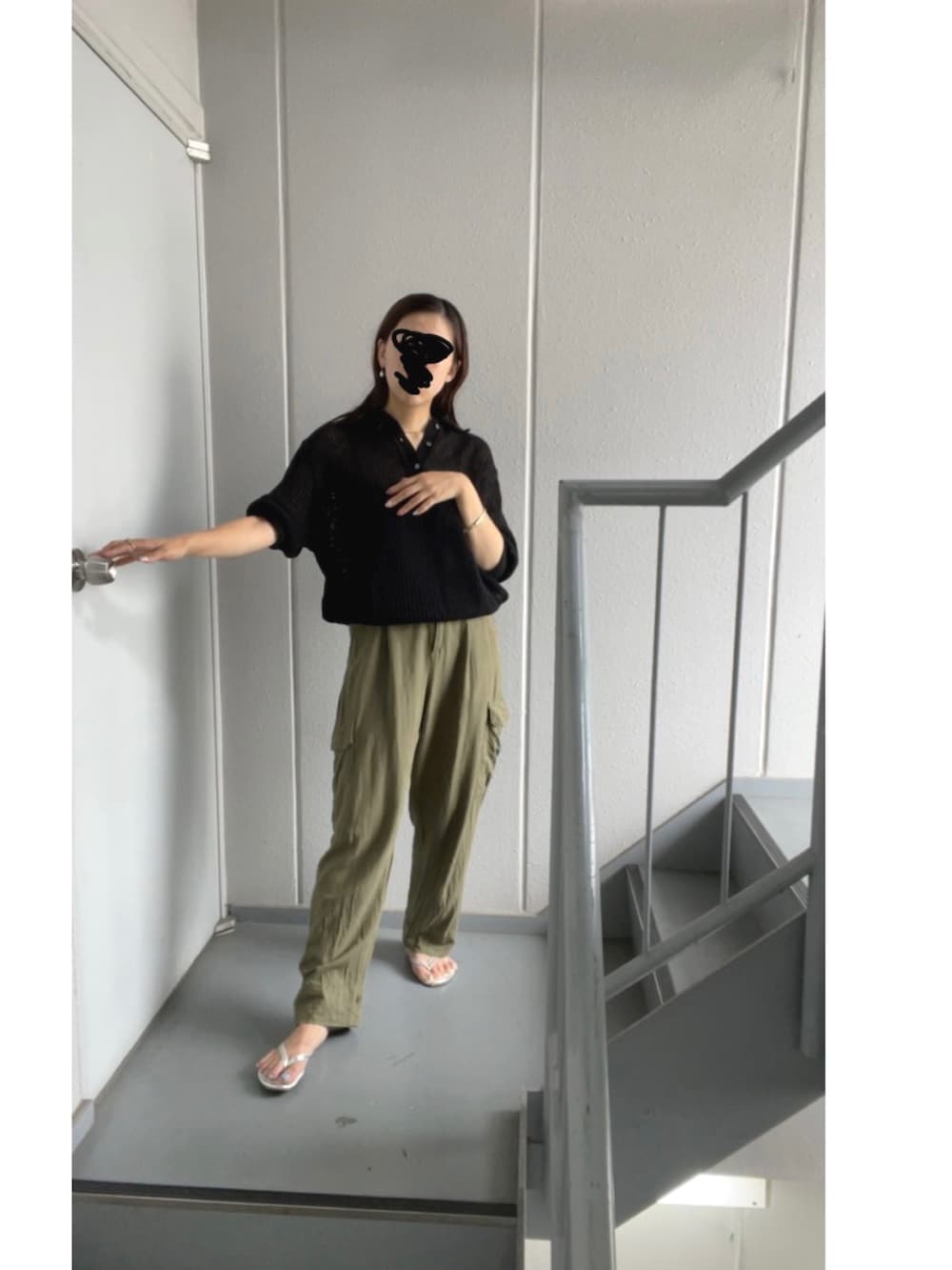 グリーン系のカーゴパンツ、ブラック系のポロシャツ、シルバー系のサンダルを着用したレディースの夏コーディネートの4枚目の写真