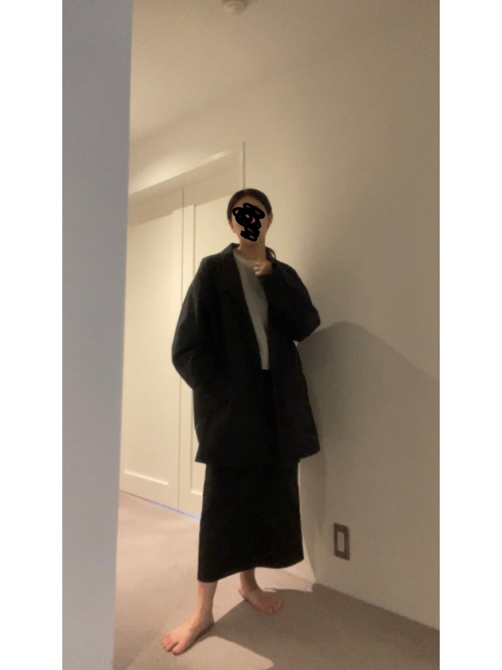 ブラック系のスカート、ホワイト系のニット/セーター、ブラック系のパンプスを着用したレディースの春コーディネートの2枚目の写真