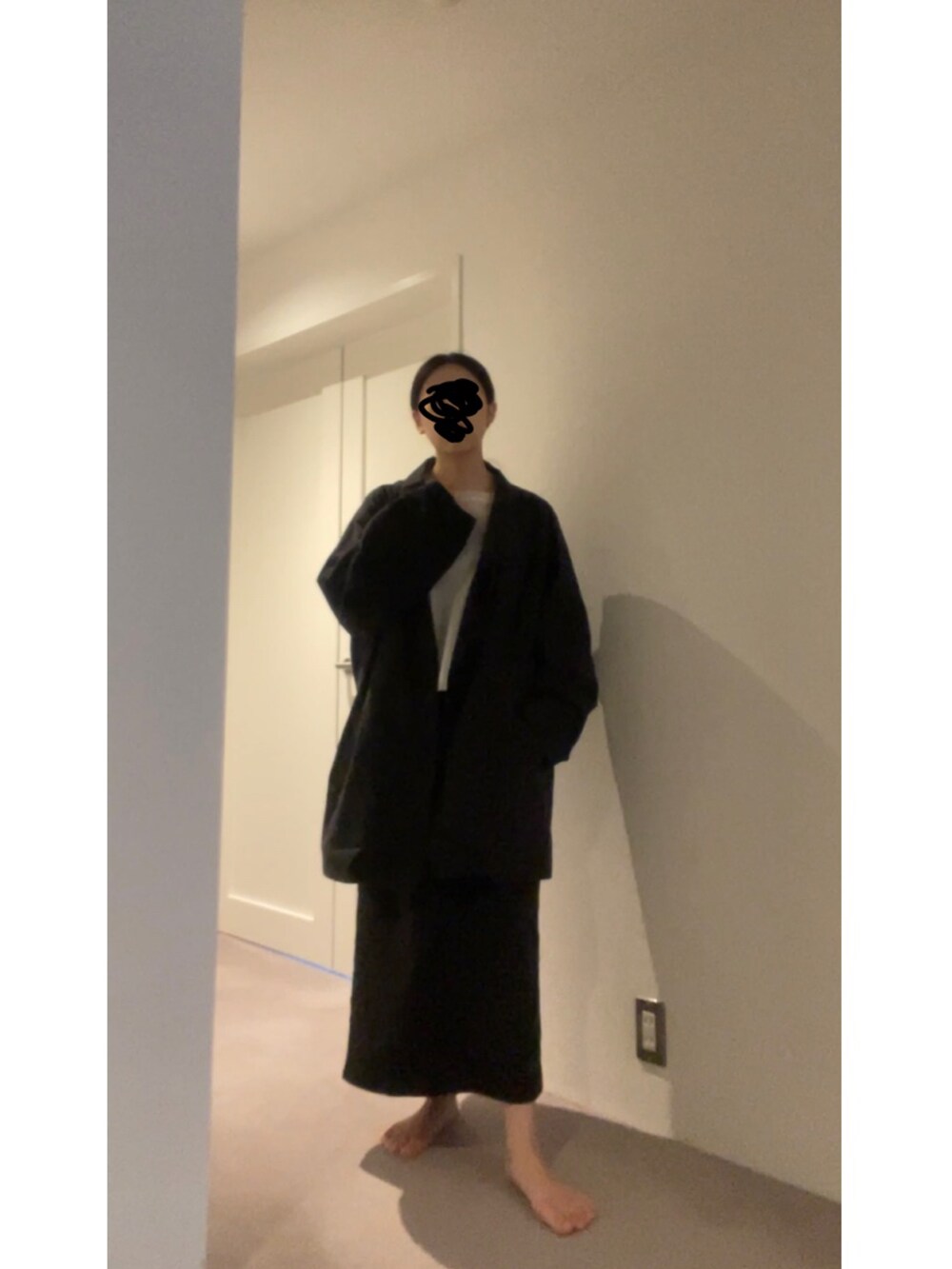 ブラック系のスカート、ホワイト系のニット/セーター、ブラック系のパンプスを着用したレディースの春コーディネートの3枚目の写真