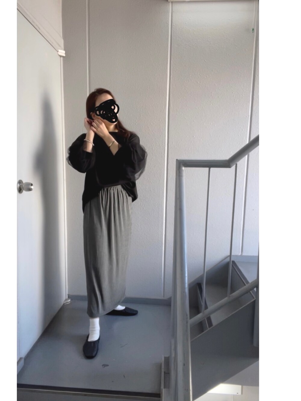 グレー系のスカートを着用したレディースの秋コーディネートの3枚目の写真