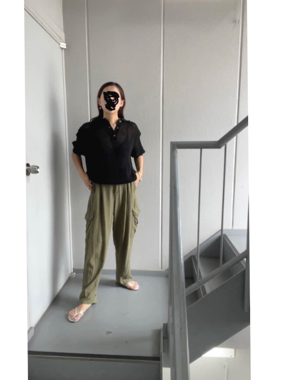 グリーン系のカーゴパンツ、ブラック系のポロシャツ、シルバー系のサンダルを着用したレディースの夏コーディネートの2枚目の写真