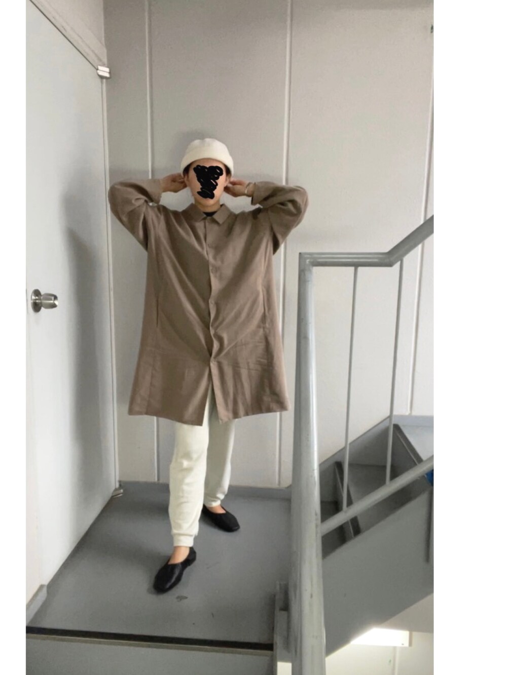 ブラウン系のステンカラーコート、ホワイト系のパンツ、ベージュ系のニットキャップ/ビーニーを着用したレディースの秋コーディネートの3枚目の写真