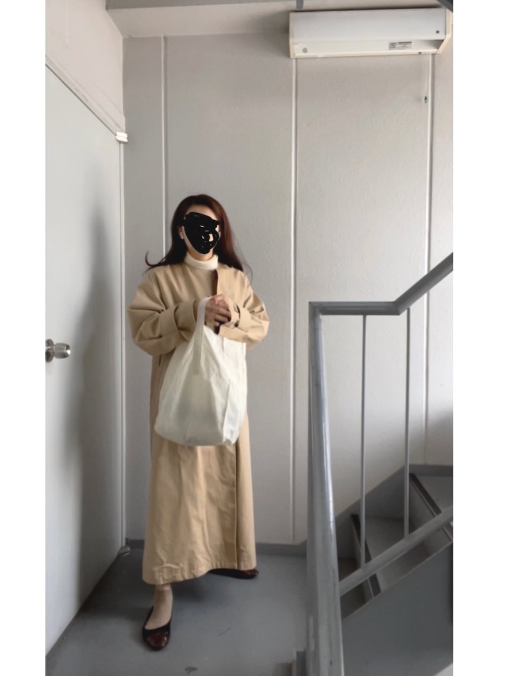 ホワイト系のトートバッグ、ホワイト系のニット/セーター、ベージュ系のトレンチコートを着用したレディースの冬コーディネートの5枚目の写真