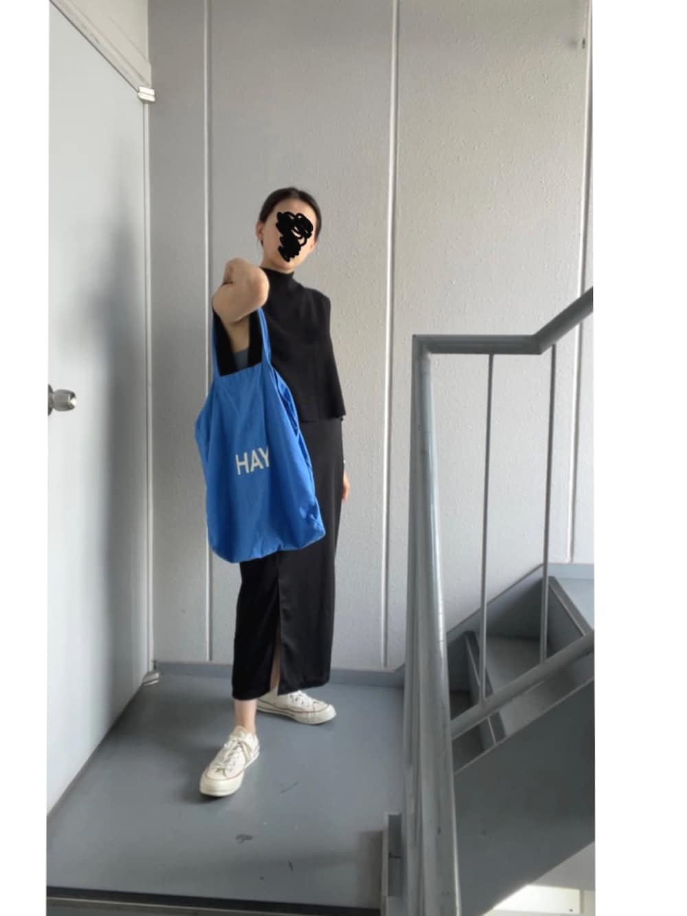ホワイト系のワンピース、ブラック系のスカート、ブルー系のトートバッグを着用したレディースの秋コーディネートの4枚目の写真
