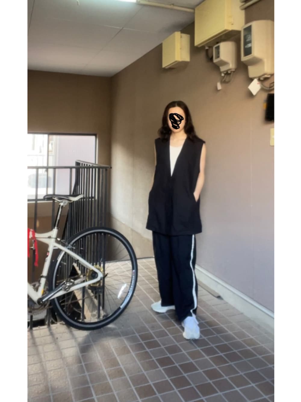 ブラック系のベスト、ブラック系のその他パンツ、ホワイト系のスニーカーを着用したレディースの春コーディネートの3枚目の写真