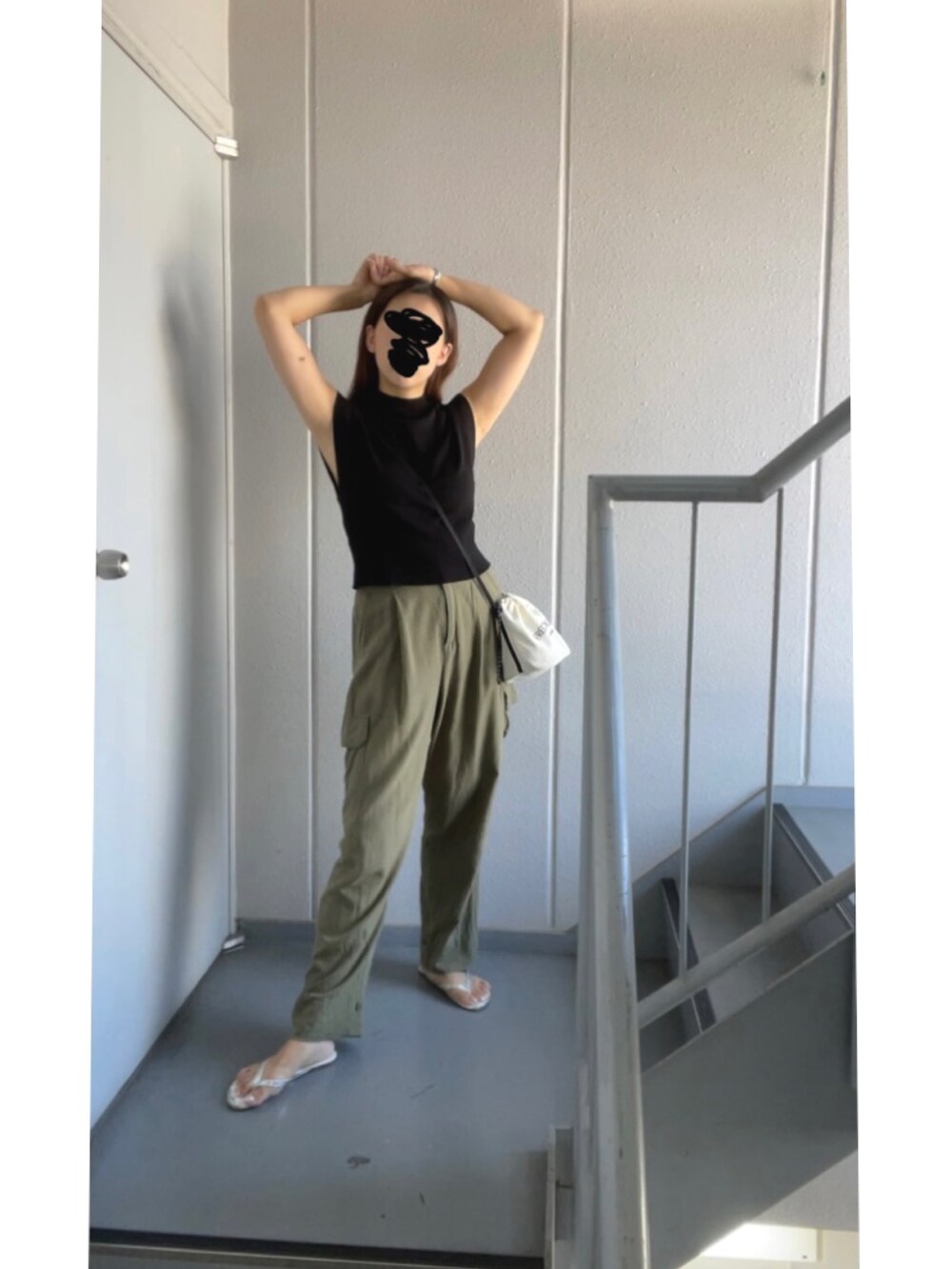 グリーン系のカーゴパンツ、ブラック系のニット/セーター、シルバー系のサンダルを着用したレディースの秋コーディネートの4枚目の写真