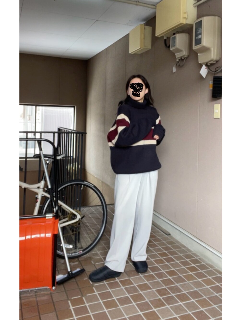 ブラック系のサンダル、グレー系のスラックスを着用したレディースの冬コーディネートの2枚目の写真