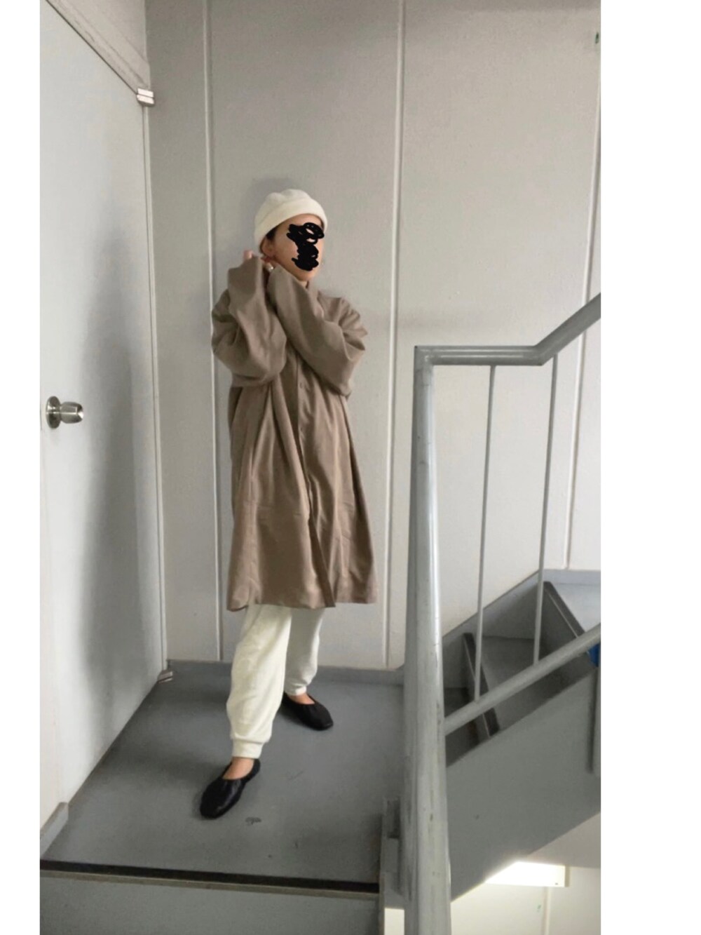 ブラウン系のステンカラーコート、ホワイト系のパンツ、ベージュ系のニットキャップ/ビーニーを着用したレディースの秋コーディネートの4枚目の写真