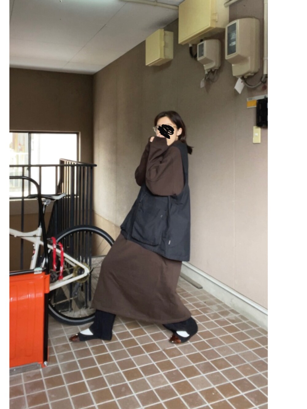 ブラウン系のワンピース、ブラック系のベスト、ブラック系のその他パンツを着用したレディースの冬コーディネートの2枚目の写真