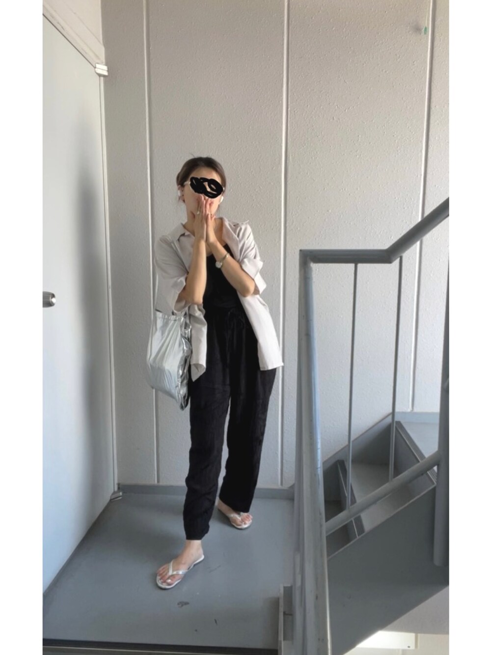 シルバー系のエコバッグ/サブバッグ、ブラック系のその他パンツ、シルバー系のサンダルを着用したレディースの夏コーディネートの3枚目の写真