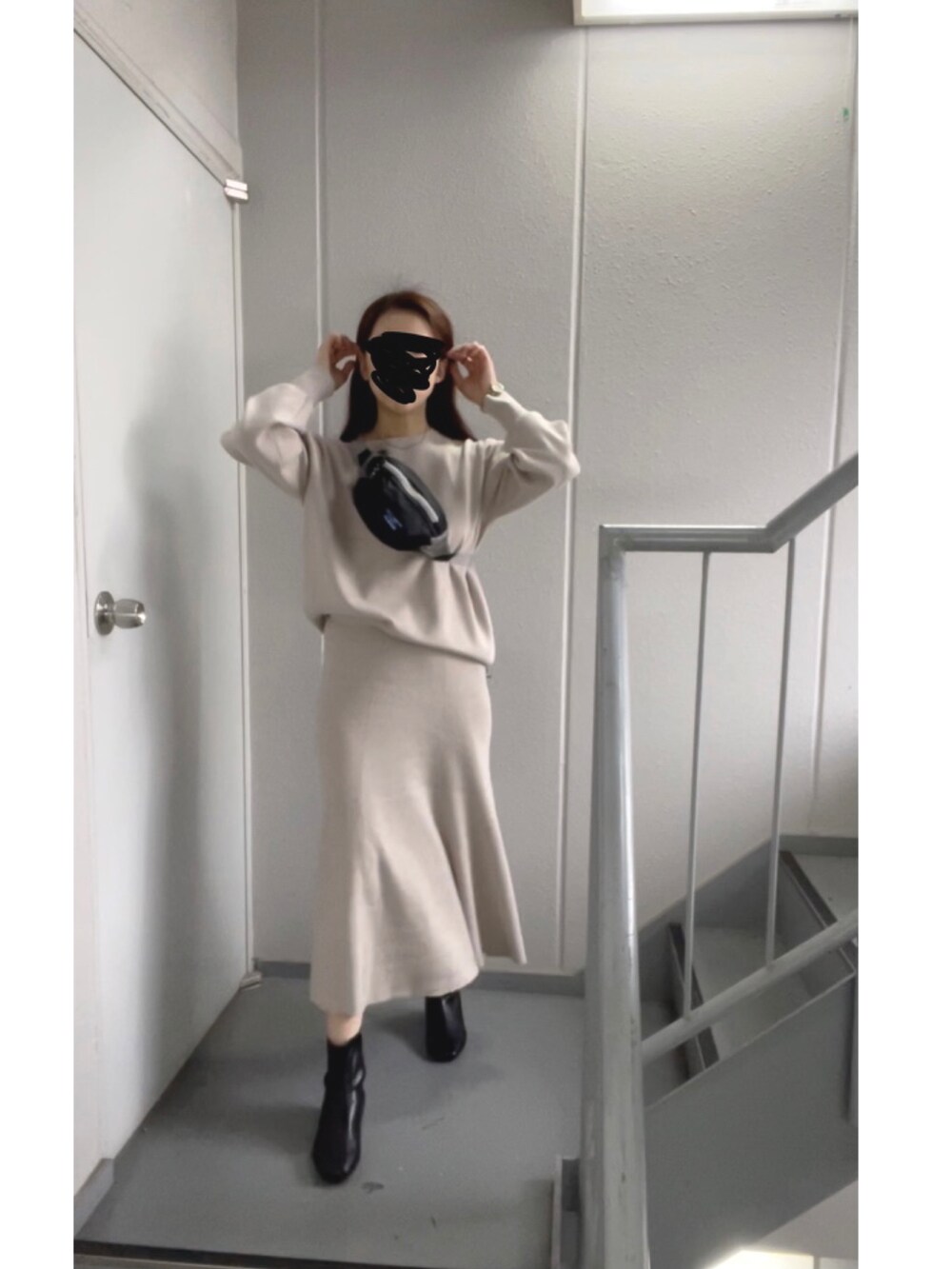 ブラック系のボディバッグ/ウエストポーチ、ブラック系のブーツを着用したレディースの冬コーディネートの2枚目の写真