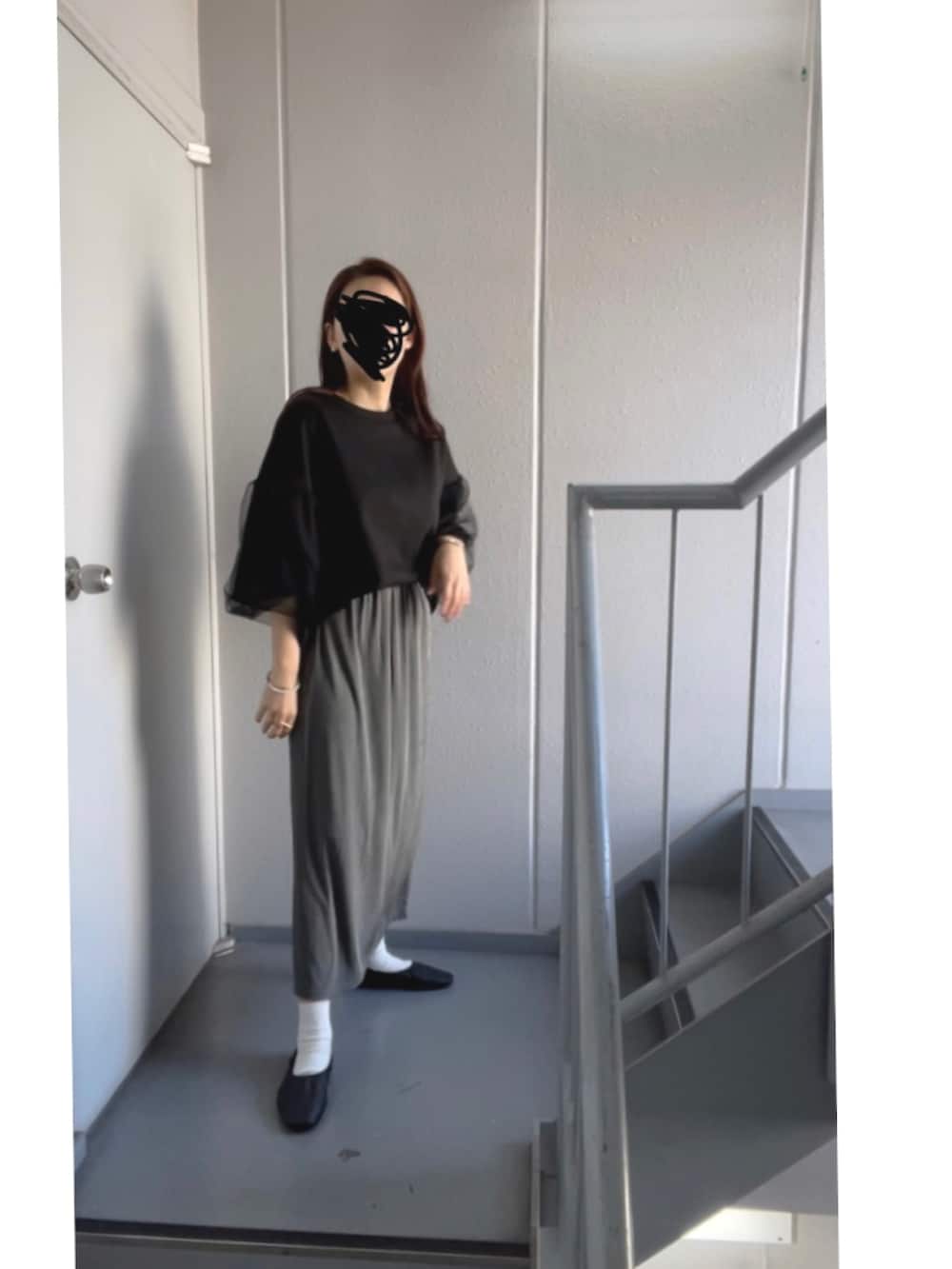 グレー系のスカートを着用したレディースの秋コーディネートの2枚目の写真