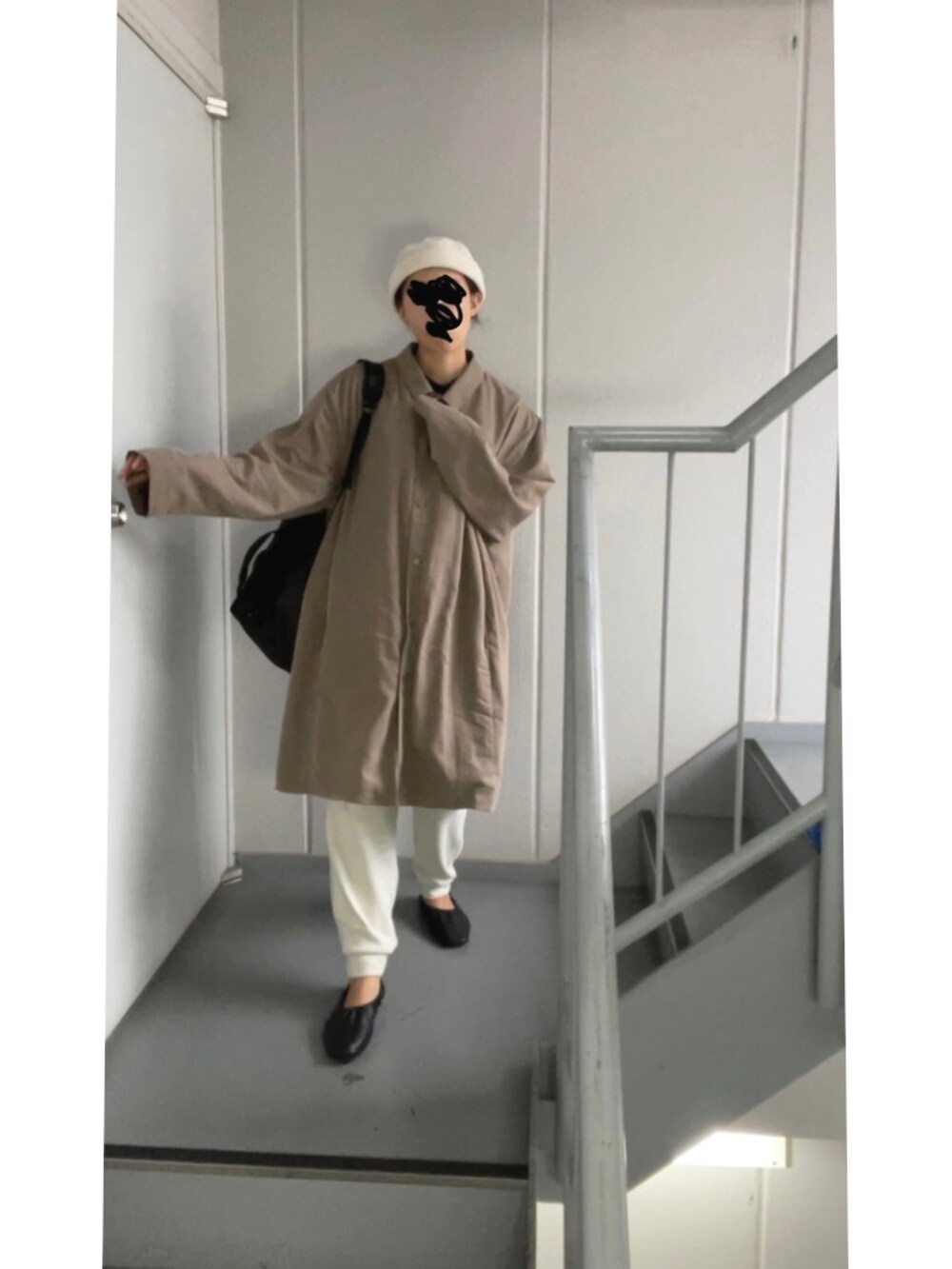 ブラウン系のステンカラーコート、ホワイト系のパンツ、ベージュ系のニットキャップ/ビーニーを着用したレディースの秋コーディネートの4枚目の写真