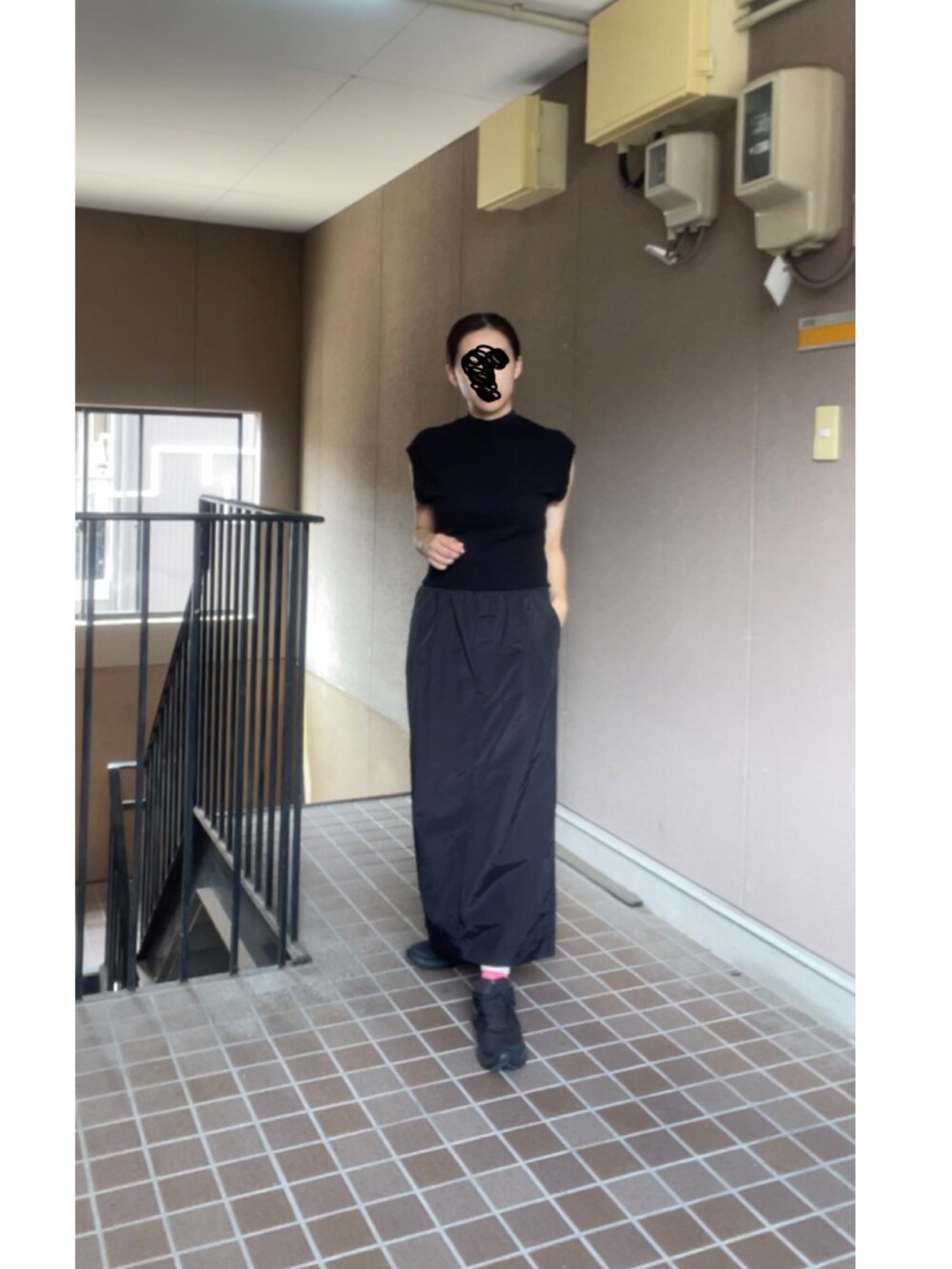 ブラック系のスカート、ブラック系のニット/セーター、ブラック系のスニーカーを着用したレディースの秋コーディネートの2枚目の写真