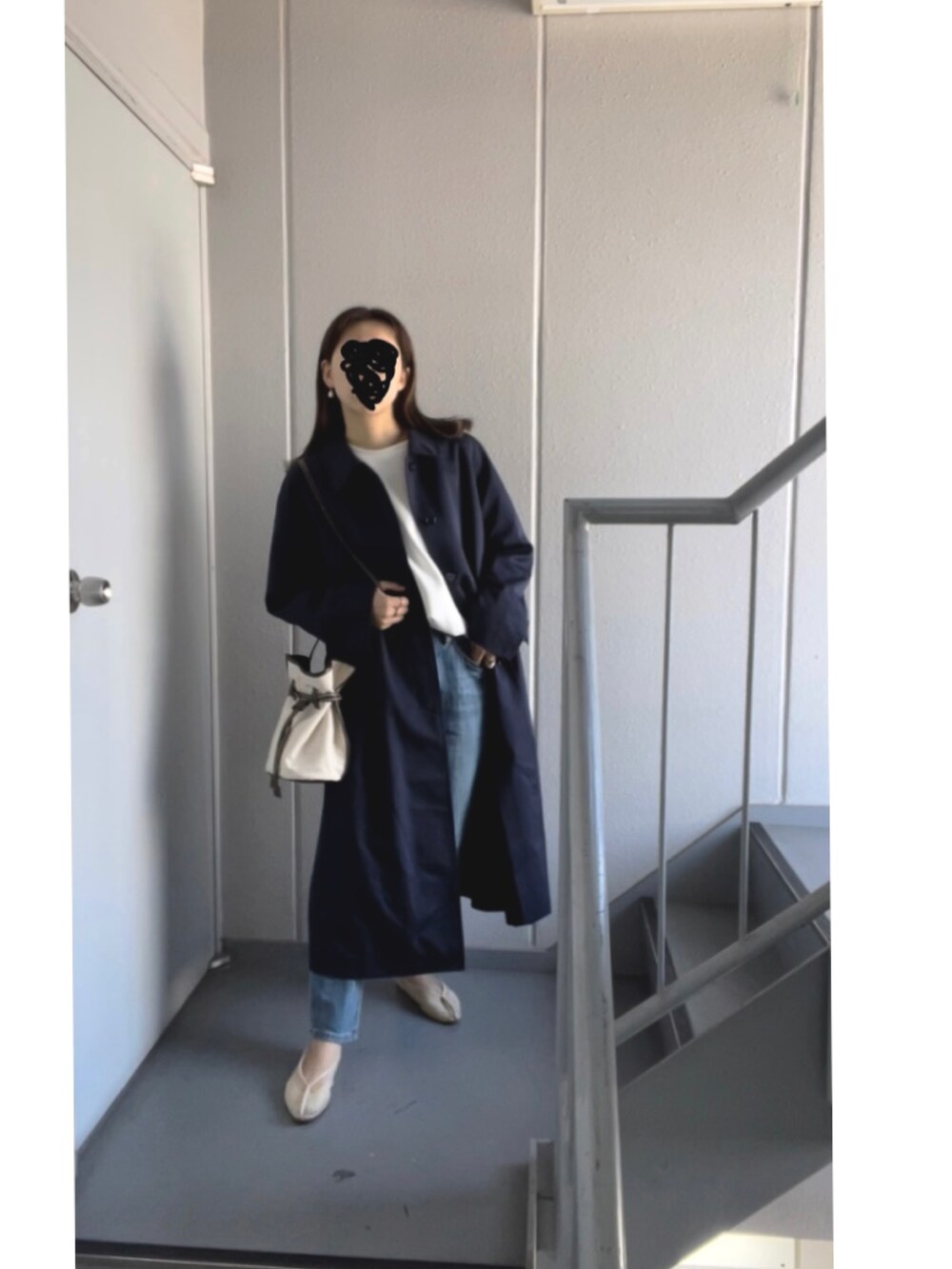 ブルー系のデニムパンツ、ホワイト系のバレエシューズ、ホワイト系のショルダーバッグを着用したレディースの春コーディネートの2枚目の写真