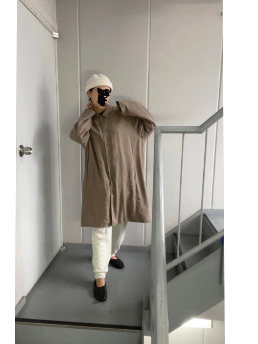 ブラウン系のステンカラーコート、ホワイト系のパンツ、ベージュ系のニットキャップ/ビーニーを着用したレディースの秋コーディネートの4枚目の写真