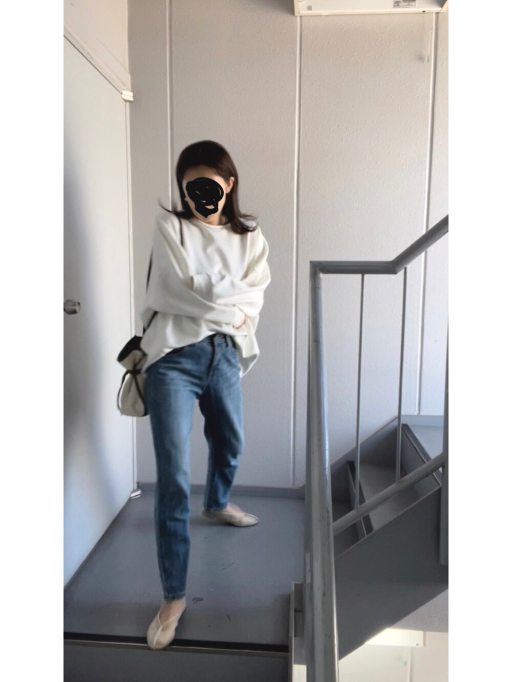 ホワイト系のショルダーバッグ、ブルー系のデニムパンツ、ホワイト系のバレエシューズを着用したレディースの春コーディネートの3枚目の写真