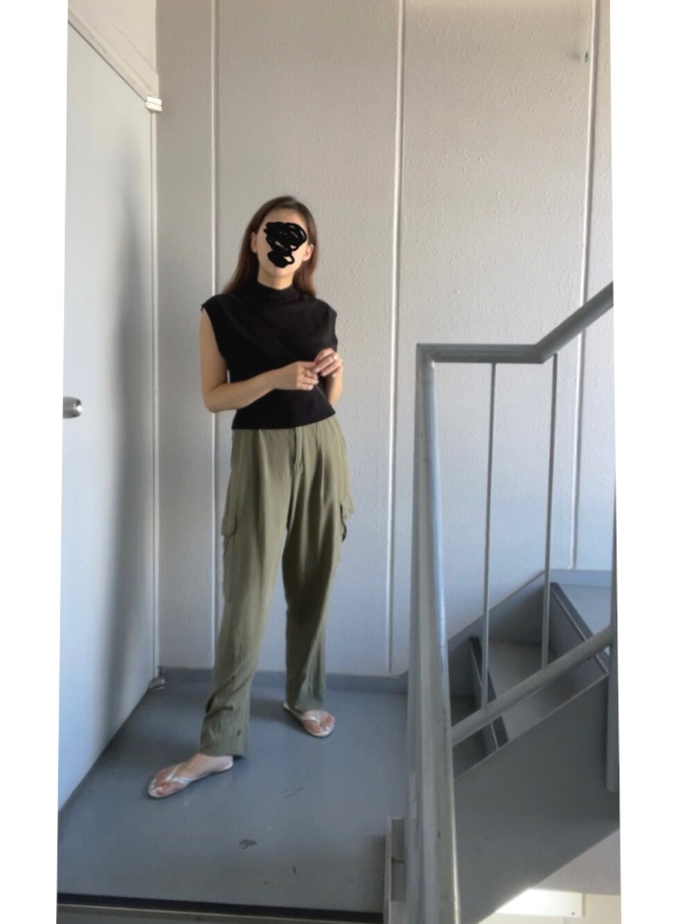 グリーン系のカーゴパンツ、ブラック系のニット/セーター、シルバー系のサンダルを着用したレディースの秋コーディネートの5枚目の写真