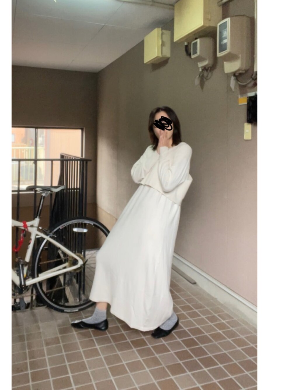 ブラック系のパンプス、ホワイト系のワンピースを着用したレディースの冬コーディネートの2枚目の写真