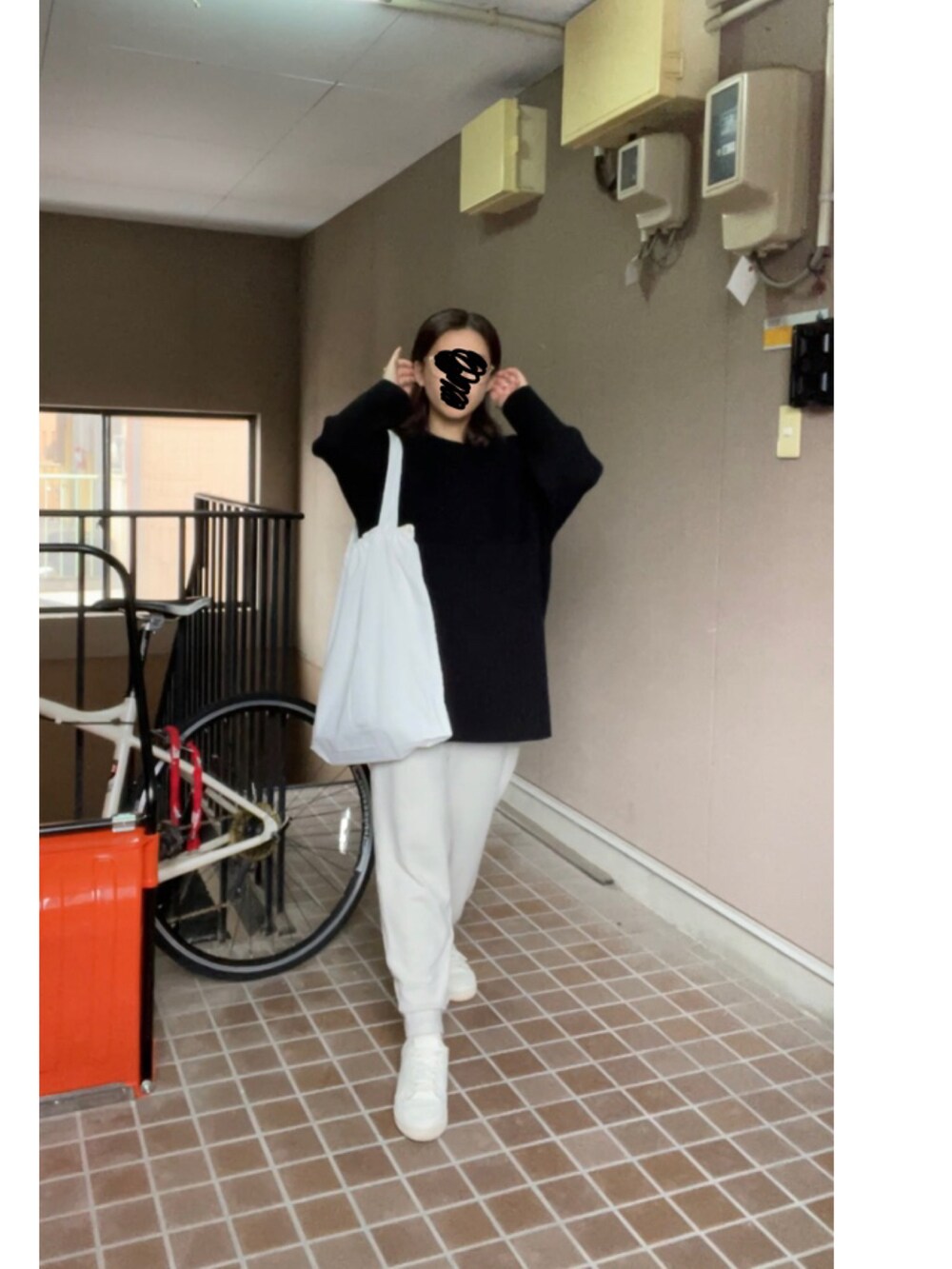 ブラック系のニット/セーター、ホワイト系のパンツ、ホワイト系のスニーカーを着用したレディースの冬コーディネートの2枚目の写真