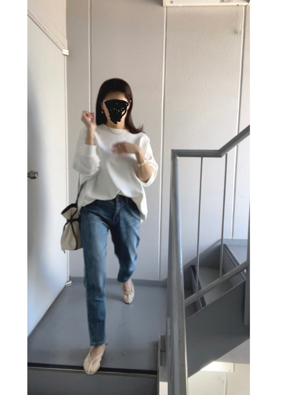 ホワイト系のショルダーバッグ、ブルー系のデニムパンツ、ホワイト系のバレエシューズを着用したレディースの春コーディネートの4枚目の写真