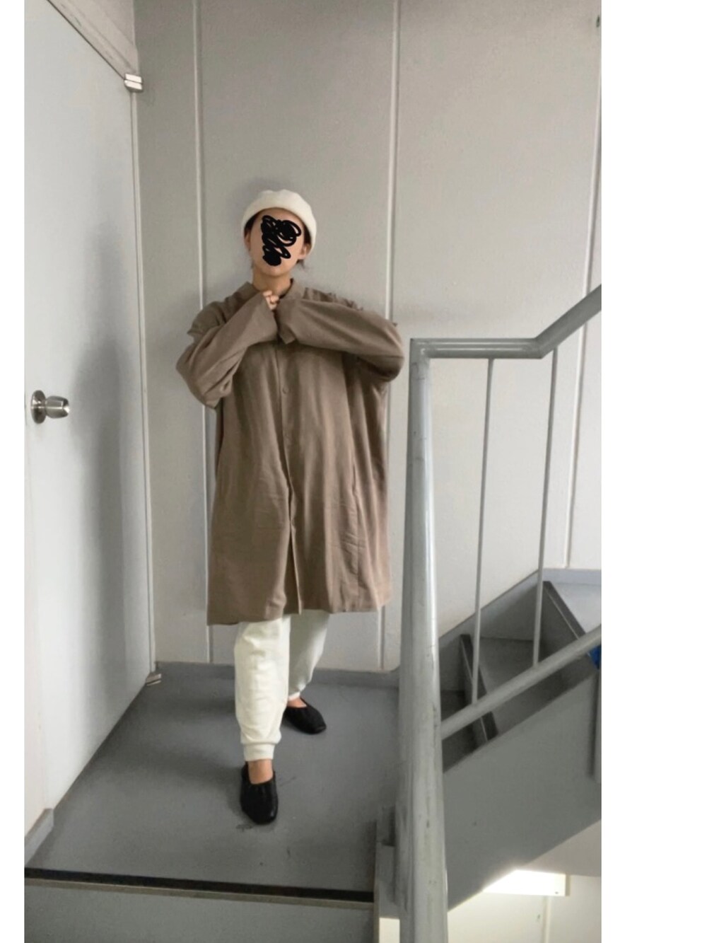 ブラウン系のステンカラーコート、ホワイト系のパンツ、ベージュ系のニットキャップ/ビーニーを着用したレディースの秋コーディネートの3枚目の写真