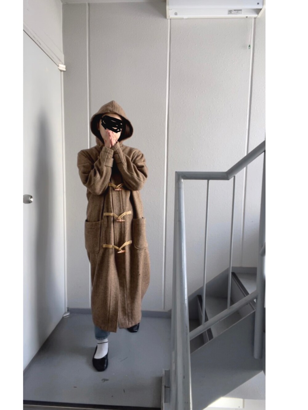 ブラック系のパンプス、ブルー系のデニムパンツを着用したレディースの冬コーディネートの4枚目の写真