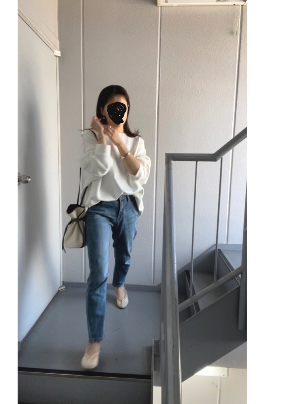 ホワイト系のショルダーバッグ、ブルー系のデニムパンツ、ホワイト系のバレエシューズを着用したレディースの春コーディネートの2枚目の写真