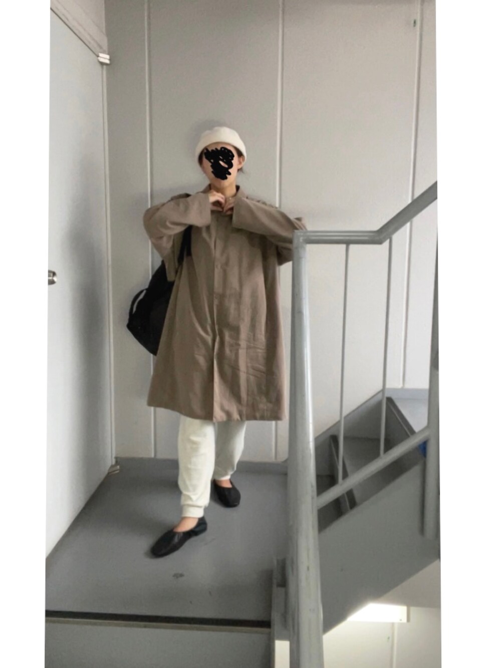 ブラウン系のステンカラーコート、ホワイト系のパンツ、ベージュ系のニットキャップ/ビーニーを着用したレディースの秋コーディネートの3枚目の写真