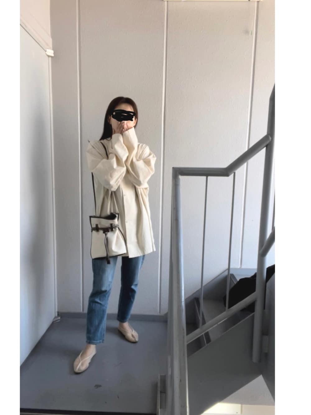 ホワイト系のシャツ/ブラウス、ホワイト系のショルダーバッグ、ブルー系のデニムパンツを着用したレディースの春コーディネートの4枚目の写真