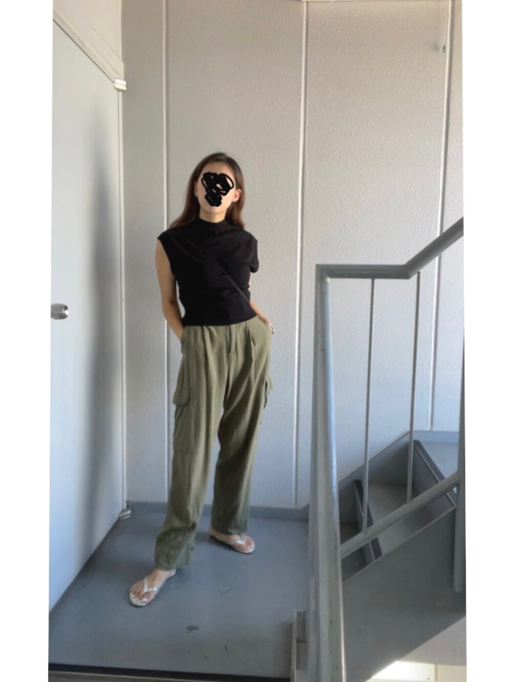 グリーン系のカーゴパンツ、ブラック系のニット/セーター、シルバー系のサンダルを着用したレディースの秋コーディネートの3枚目の写真