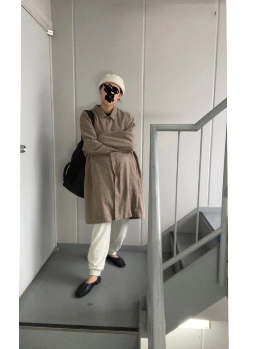 ブラウン系のステンカラーコート、ホワイト系のパンツ、ベージュ系のニットキャップ/ビーニーを着用したレディースの秋コーディネートの5枚目の写真