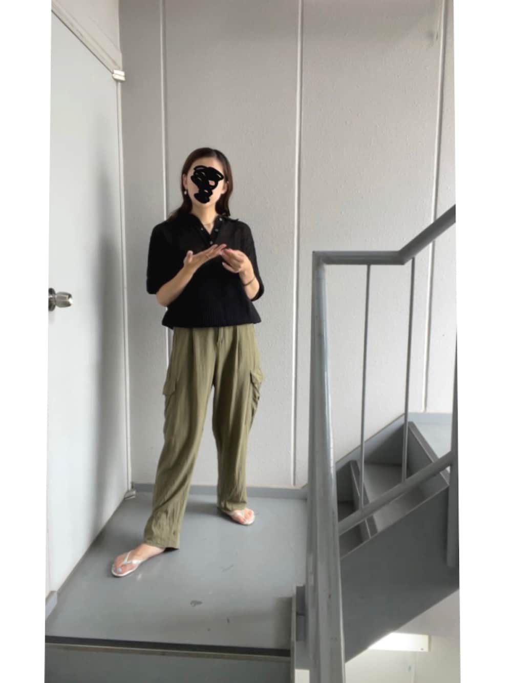 グリーン系のカーゴパンツ、ブラック系のポロシャツ、シルバー系のサンダルを着用したレディースの夏コーディネートの3枚目の写真